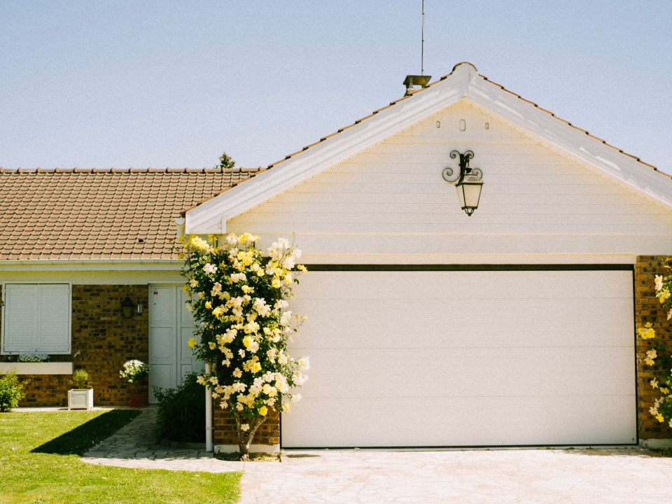 Garage mit Str&auml;uchern auf der Seite der Einfahrt