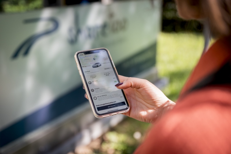 Eine_Frau_nutzt_eine_Carsharing-App_auf_ihrem_Smartphone