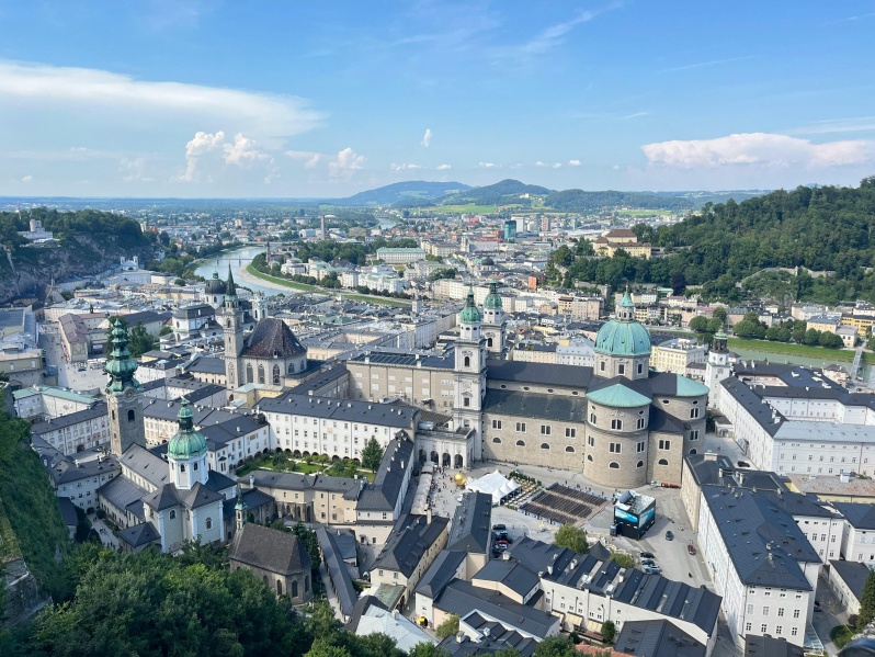 Die Stadt Salzburg mit ihren historischen Gebäuden und den Alpen im Hintergrund.